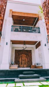 a large room with a wooden door and a balcony at Budha Manis Villa in Kerobokan