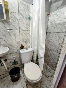 La salle de bains blanche est pourvue de toilettes et d'un lavabo. dans l'établissement Solar palmer 6, à Cabo Frio