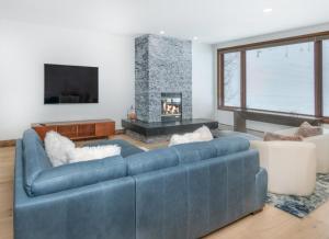 a living room with a blue couch and a fireplace at Highlands Slopeside #221 condo in Beaver Creek