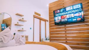 a bedroom with a television on a wooden wall at Budha Manis Villa in Kerobokan