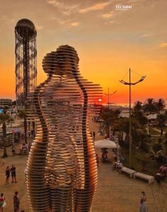 a statue of a man with the sunset in the background at Orbi City Luxury Resort in Batumi