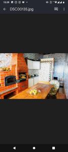 eine Küche mit einem Holztisch und einer Ziegelwand in der Unterkunft COLONIAL CÍCERO POMBO in Petrolina