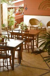 un restaurante con mesas, sillas y macetas en The Nuga House, en Ahangama