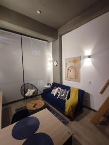 ein Wohnzimmer mit einem blauen Sofa und einem Fenster in der Unterkunft Chic Loft en Chapinero 301 in Bogotá