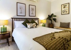 a bedroom with a large white bed and two lamps at Casa Tropicana Villa with Ocean Views - Steps from Beach Surfs Up! in Sapphire Beach
