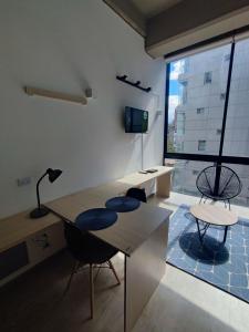 Zimmer mit einem Tisch und Stühlen sowie einem großen Fenster in der Unterkunft Chic Loft en Chapinero 301 in Bogotá