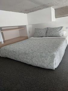 ein Schlafzimmer mit einem großen Bett mit einer weißen Wand in der Unterkunft Chic Loft en Chapinero 301 in Bogotá