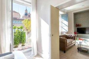 a living room with a couch and a large window at Precioso APT en la Plaza de la PAJA LATINA in Madrid