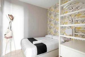 a white bedroom with a bed and a wall at Precioso APT en la Plaza de la PAJA LATINA in Madrid