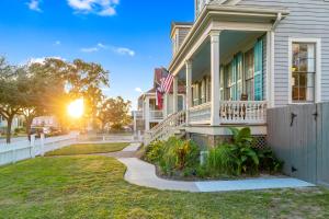 une maison arborant un drapeau américain sur la terrasse couverte dans l'établissement Historic 1871 Coastal Breeze with Heated Pool - Restoring Galveston, à Galveston 26 autres photos