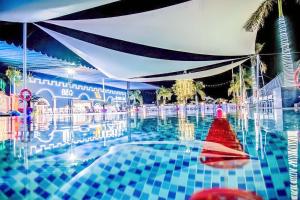 una piscina con un objeto rojo en el agua en D'Villa Hotel - Homestay, en Kon Tum