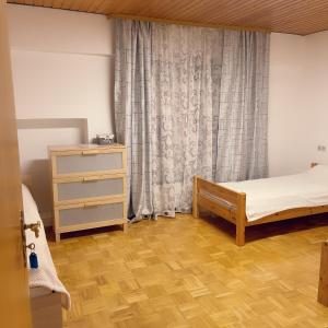 - une chambre avec un lit, une commode et une fenêtre dans l'établissement Familienhaus, à Niedenstein