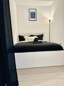 a white bedroom with a bed with a black blanket at Cozy 2 Bedroom by Eaton Centre Mall in Toronto