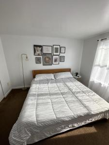 uma cama grande num quarto com fotografias na parede em Cheerful Two Bedroom Central Location Downtown em Baltimore