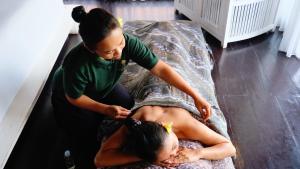 a woman is giving a woman a massage at Kayangan Villa Ubud in Tegalalang