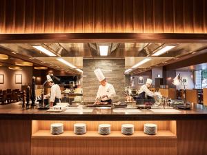 un groupe de chefs dans une cuisine préparant des plats dans l'établissement Hotel Metropolitan Tokyo Ikebukuro, à Tokyo