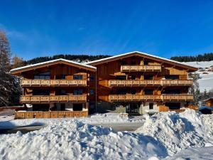 ein großes Holzgebäude mit Schnee davor in der Unterkunft Appartement Notre-Dame-de-Bellecombe, 3 pièces, 4 personnes - FR-1-505-203 in Notre-Dame-de-Bellecombe