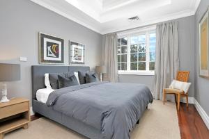 Un dormitorio con una cama grande y una ventana en The Grande Port Stephens Luxurious golf and beach getaway on Horizons Golf Resort en Salamander Bay
