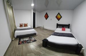 1 dormitorio con 2 camas y alfombra en Finca ARES en Filandia