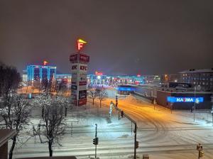 a snow covered parking lot with a city at night at Energia 2 Apartment in the city center in Narva