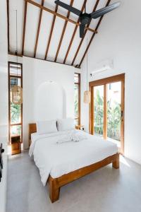 een witte slaapkamer met een groot bed met witte lakens bij New 1 Bedroom Villa Baru 9 in Canggu