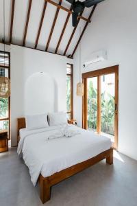een slaapkamer met een groot bed met witte lakens bij New 1 Bedroom Villa Baru 9 in Canggu