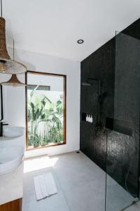 ein Bad mit einer Glasdusche und einem Waschbecken in der Unterkunft New 1 Bedroom Villa Baru 9 in Canggu
