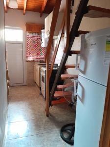 a small kitchen with a refrigerator and a staircase at Complejo Extremo in Mar de Ajó