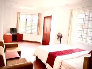 Schlafzimmer mit einem Bett, einem Stuhl und Fenstern in der Unterkunft Vera Hotel Hà Nội in Hanoi
