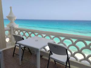 a table and chairs on a balcony overlooking the ocean at “Magic Sunrise at Cancun” in Cancún