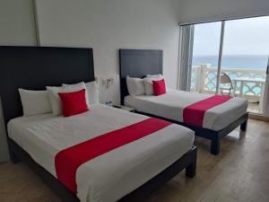 two beds in a hotel room with a view of the ocean at “Magic Sunrise at Cancun” in Cancún