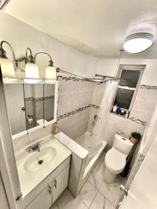 a white bathroom with a sink and a toilet at 2 Bedrooms apartament one stop from Manhattan in Weehawken