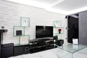 ein Wohnzimmer mit einem TV und einem Glastisch in der Unterkunft Modern Loft in Paris Center! in Paris