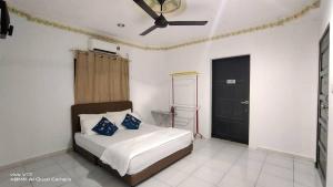 a bedroom with a bed and a ceiling fan at CHILL GUEST HOUSE CENANG in Pantai Cenang