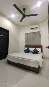 um quarto com uma cama e uma ventoinha de tecto em CHILL GUEST HOUSE CENANG em Pantai Cenang