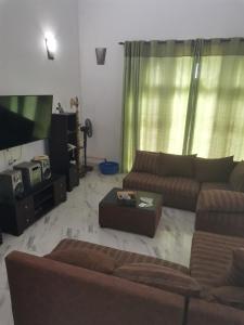 a living room with couches and a flat screen tv at Kandy ambuluwawa mount villa in Angammana