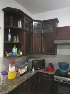 uma cozinha com armários de madeira e um micro-ondas em Kandy ambuluwawa mount villa em Angammana