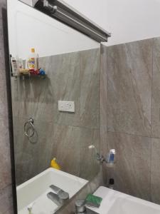 a bathroom with a shower and a sink and a mirror at Kandy ambuluwawa mount villa in Angammana