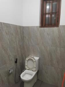 a bathroom with a toilet with a hose at Kandy ambuluwawa mount villa in Angammana
