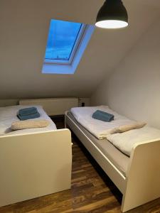 two beds in a room with a window at Ferienwohnung Jule in Wernigerode