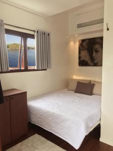 a bedroom with a bed and a large window at Nyaman Catamaran, a Nusa Penida Cruise in Semarapura