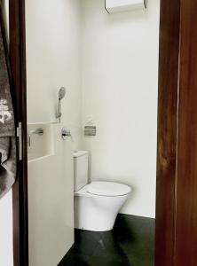 a bathroom with a white toilet in a room at Nyaman Catamaran, a Nusa Penida Cruise in Semarapura