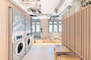 a laundry room with a washer and dryer at Jyu Capsule Hotel in Singapore