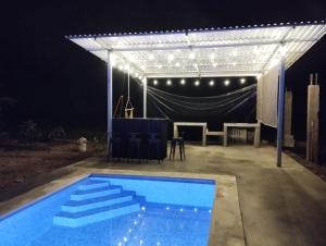 eine Pergola und ein Schwimmbad in der Nacht in der Unterkunft VILLA LAS LAPAS in San Buenaventura