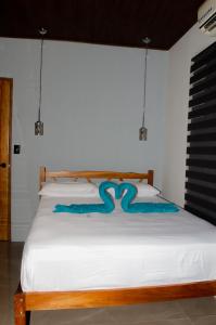 ein weißes Bett mit einer blauen Schlange drauf in der Unterkunft VILLA LAS LAPAS in San Buenaventura