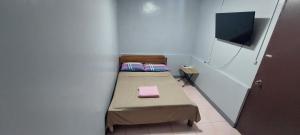 Kleines Zimmer mit einem Bett und einem TV in der Unterkunft Genna's Tourist Inn Standard Room in Pooc