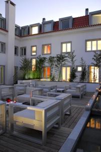 a building with tables and benches on a deck at Hotel Jeronimos 8 in Lisbon