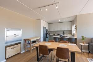 a kitchen and dining room with a table and chairs at Nivica 46 Luxury Apartment Langebaan in Langebaan