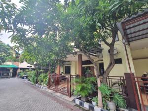 a building with trees and plants in front of it at OYO 93444 Damia Homestay Syariah in Surabaya