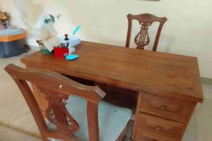 a wooden desk with a chair and a wooden table and a desk at SPOT ON 93436 Penginapan Mekar Sari in Kuripan